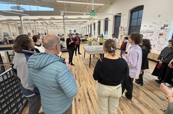 Instructor Jesse Voigt gives jurors an introduction to her studio's Ai-incorporated project prior to final critiques.