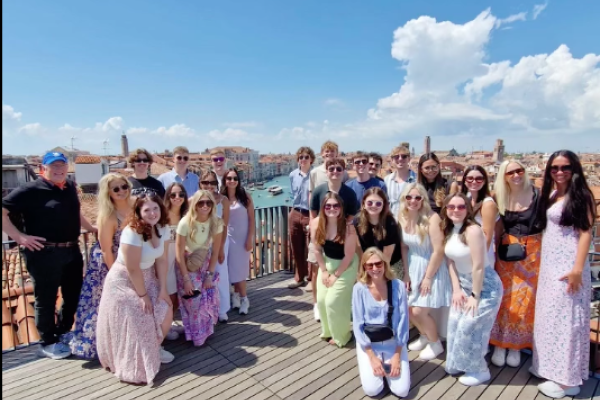 The group poses on a panoramic terrace in Venice.