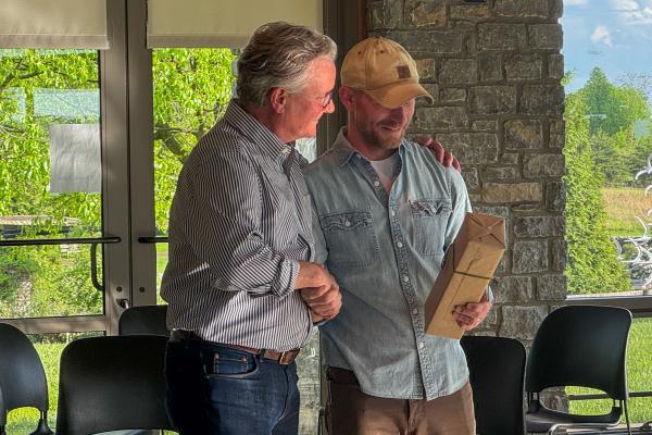 Jon Mills shakes Dean Ned Crankshaw's hand as he receives a special honor.