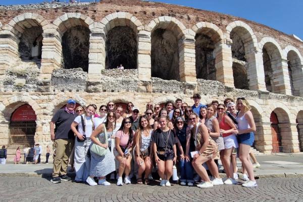 Studets stand in front of ancient sites in Italy while on education abroad
