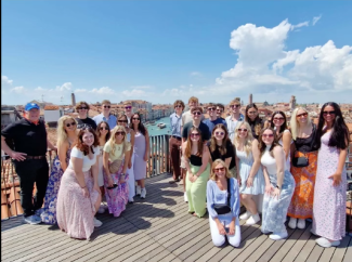 The group poses on a panoramic terrace in Venice.