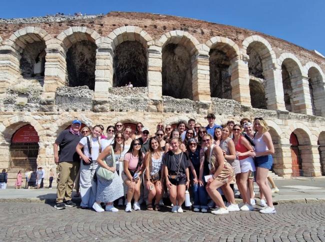Studets stand in front of ancient sites in Italy while on education abroad