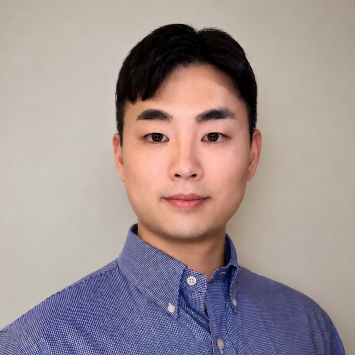 Professional headshot of a young man with short black hair wearing a blue button-down shirt, facing the camera with a calm, neutral expression.